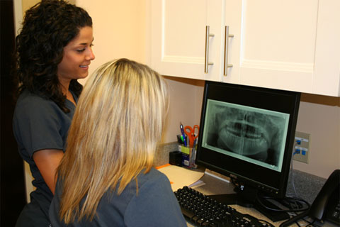 Interior photo: Oral Surgery Staff at front desk with digital patient records